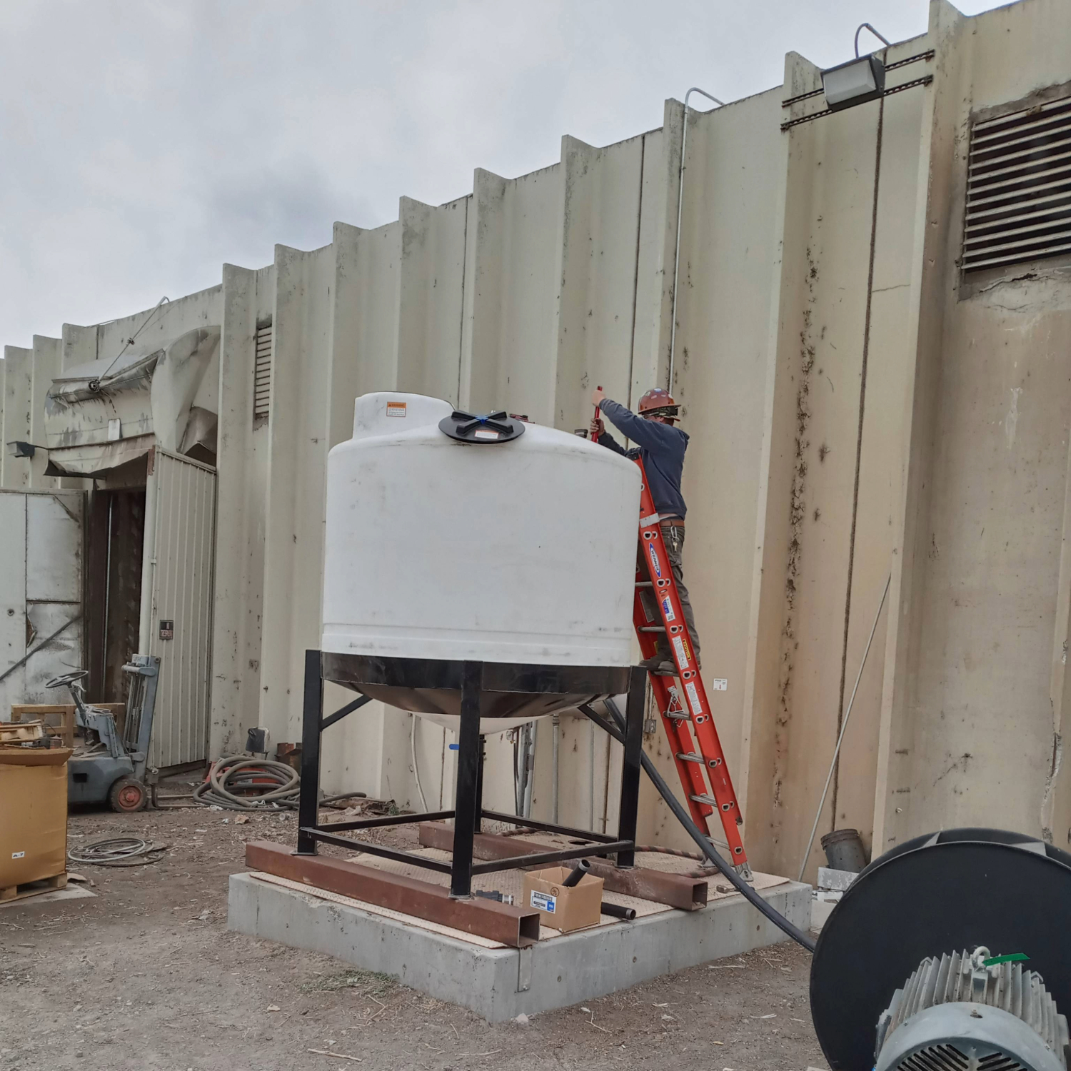 A Water-Re technician installing a chemical mix tank at a customer plant